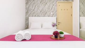 Una habitación de hotel con una cama, una puerta y un espejo.