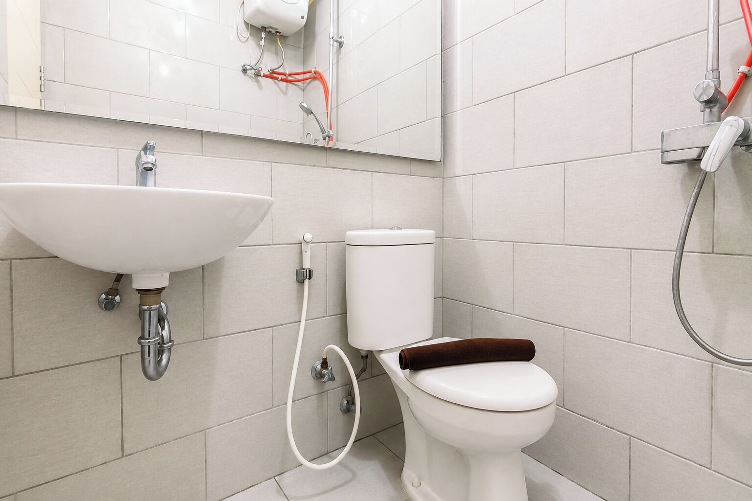 A bathroom with a white sink, toilet, and shower.