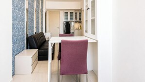 A compact kitchen with a dining area, a sofa, and a refrigerator. - Serene Spacious 2Br At Apartment Benson Supermall Mansion (Surabaya)