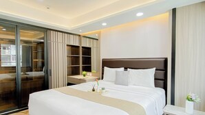 Habitación de hotel con una cama grande, una mesita de noche, un armario y una puerta corrediza de vidrio que da a un balcón.
