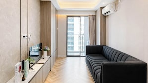 Una sala de estar moderna con un sofá, un televisor y un aparador.