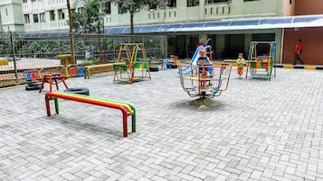 A playground with various play structures and a bench.