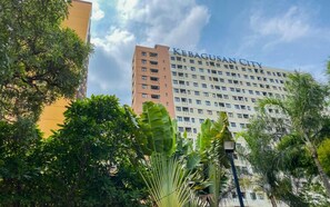 A multi-story building with 'KEBAGUSAN CITY' written on the facade, surrounded by greenery. - Strategic Location Studio At Apartment Kebagusan City (Jakarta)