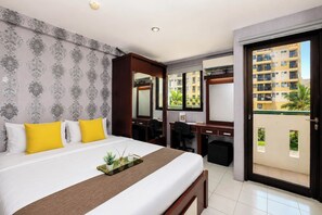 A hotel room with a bed, desk, and a balcony with a view of buildings. - Strategic Location Studio At Apartment Kebagusan City (Jakarta)