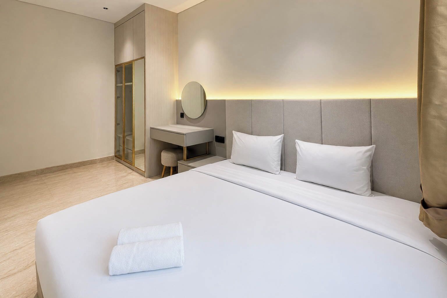 Een hotelkamer met een bed, bureau, stoel en spiegel.