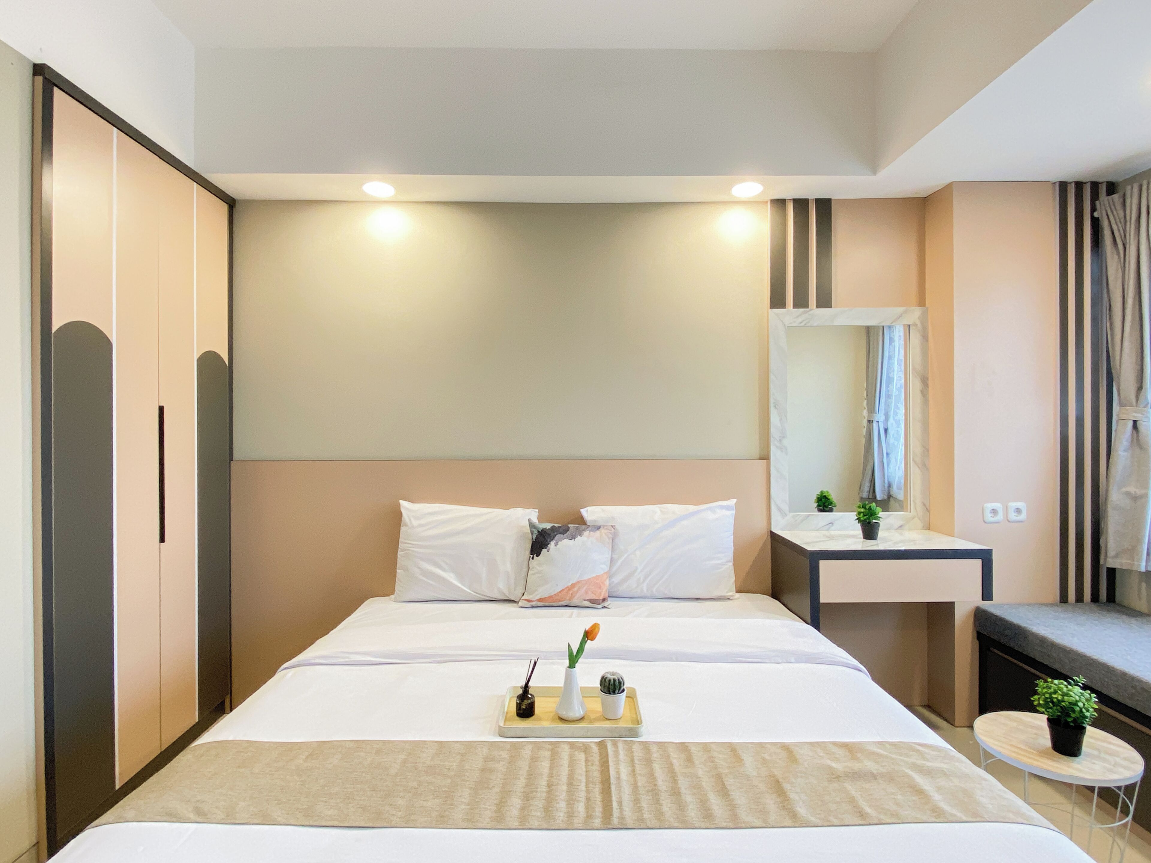 Una habitación de hotel con cama, mesita de noche y espejo.