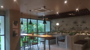 A modern kitchen with a central island, pendant lighting, and a view of greenery outside. - Good Neat Studio Room At Apartment Lrt City Jatibening (Bekasi)
