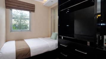Quarto com cama, janela, televisão e guarda-roupa.