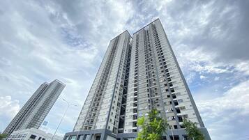 A high-rise building with multiple floors, balconies, and a clear sky.