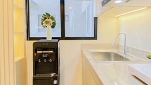 Una cocina moderna con dispensador de agua integrado, un lavamanos de acero inoxidable y un ventanal con vistas.