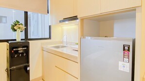 Una cocina compacta con refrigerador, horno integrado y lavamanos.