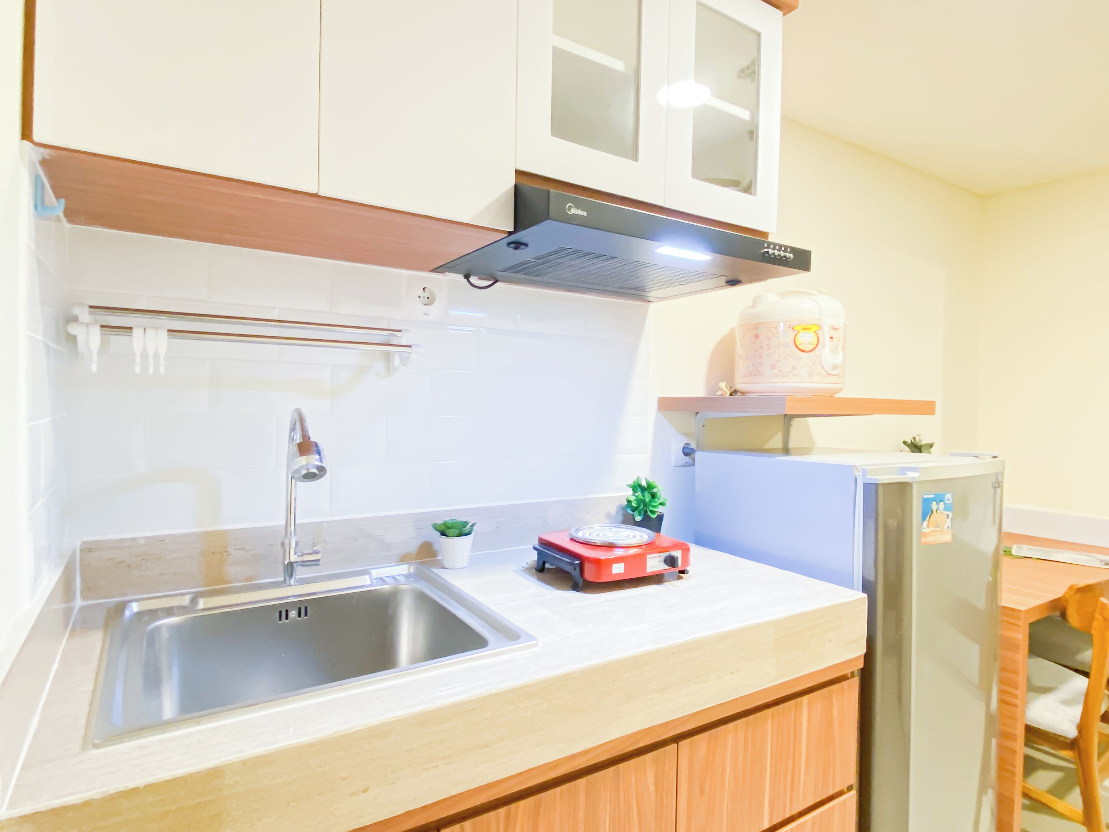A kitchen with a stainless steel sink, a built-in oven, and a refrigerator.