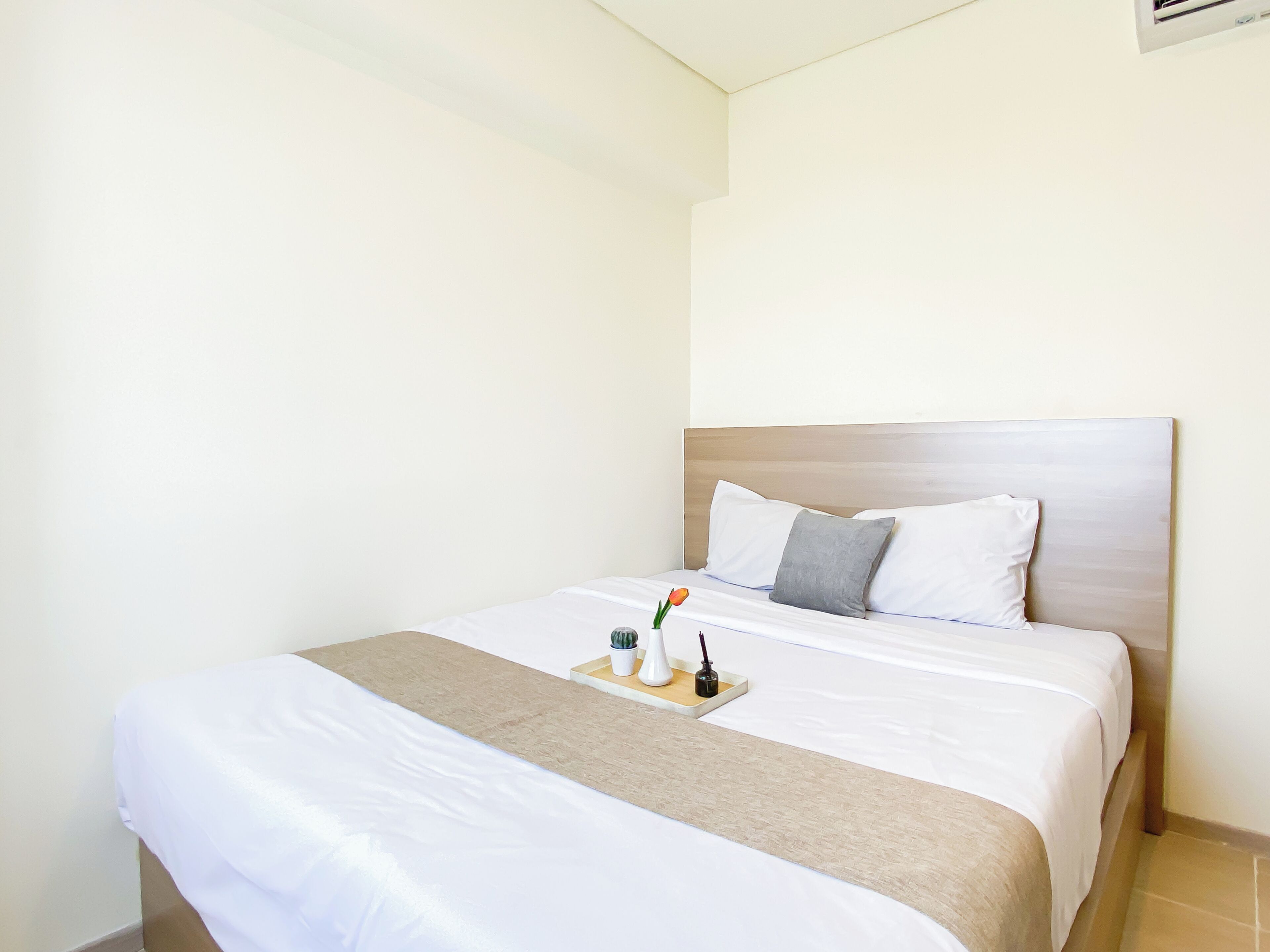 Une chambre d’hôtel équipée d’un lit, d’une table de chevet et d’un climatiseur fixé au mur.