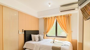 Habitación de hotel con cama, cortinas, aire acondicionado y ventana.