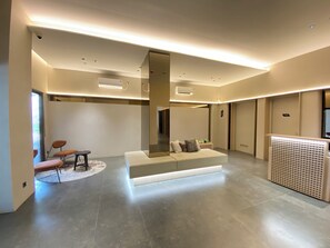 Ein modernes Interieur mit einer zentralen Sitzecke, einem großen Spiegel und einer Heizung.