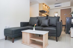 Ein modernes Wohnzimmer mit einem Ecksofa, einem kleinen Holztisch und einer Vase mit einer Blume.