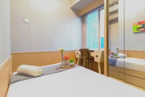 A hotel room with a bed, a desk, a chair, and a window. - Enjoy Living 2Br Apartment At Tanglin Supermall Mansion (Surabaya)