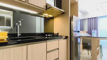 A modern kitchen with a stainless steel range hood, a double sink, and a built-in refrigerator.