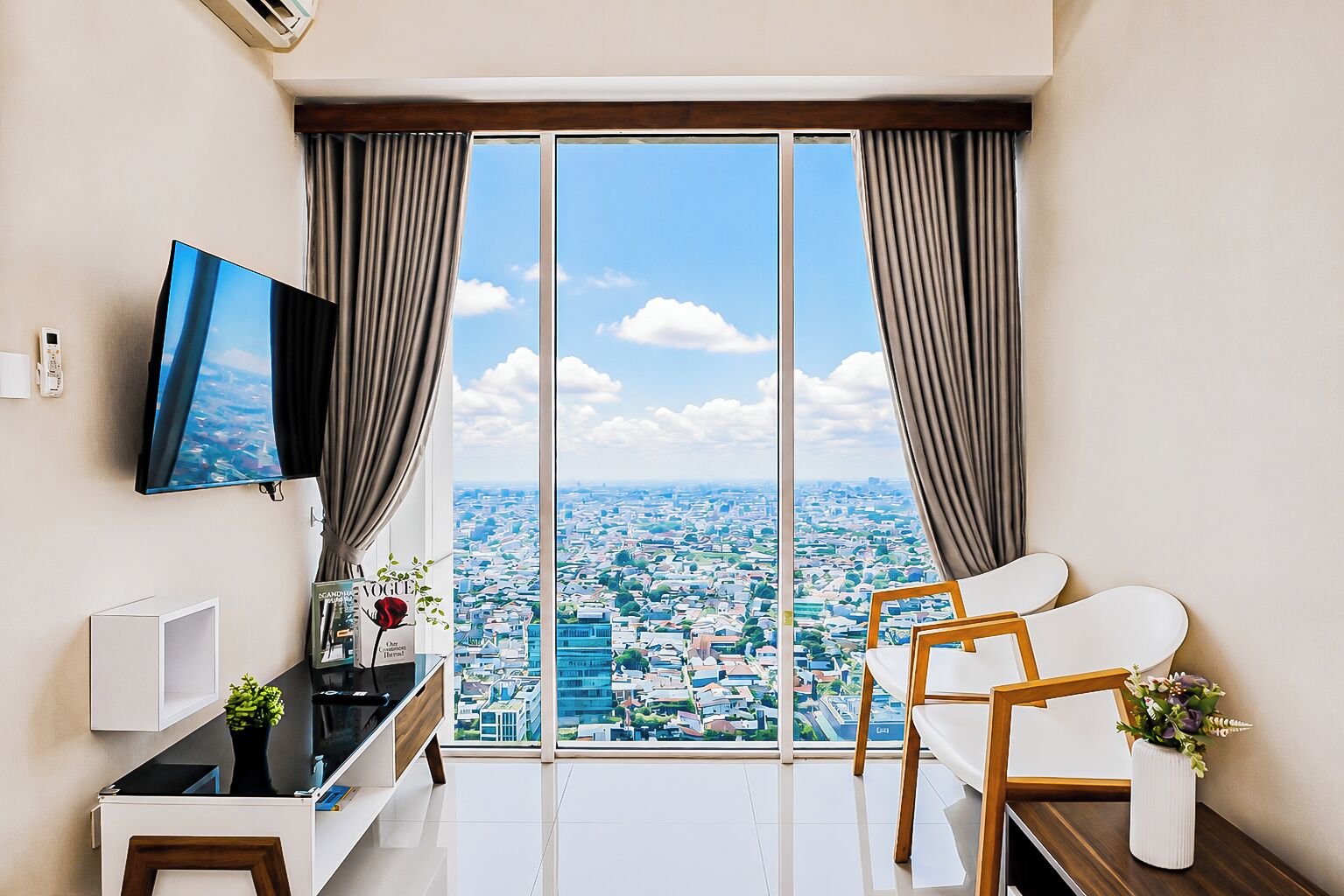 Una sala de estar moderna con un ventanal grande, un televisor de pantalla plana, un sofá y una mesa de centro.