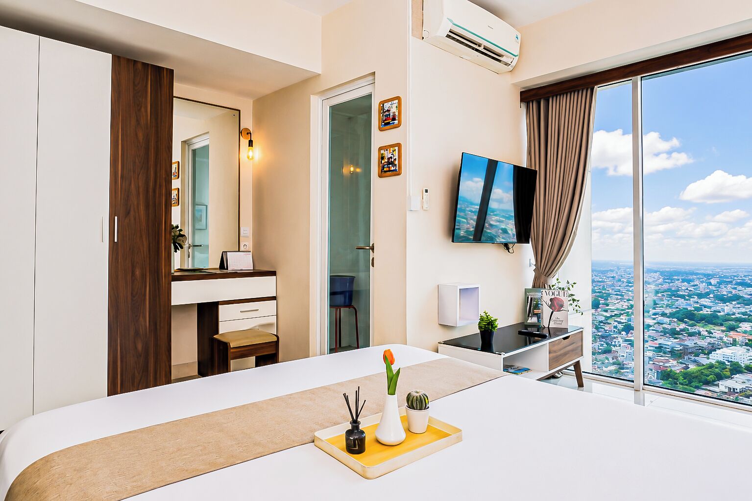 Une chambre d’hôtel avec un grand lit, un bureau, une télévision et une vue sur la ville.