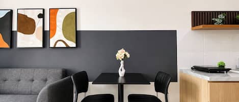 Una cocina moderna con una mesa de comedor, sillas y un florero con flores.