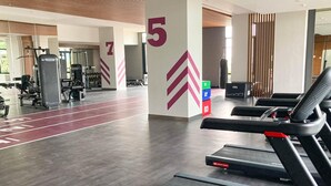 Ett gym med löpband, styrketräningsmaskiner och träningsmattor.
