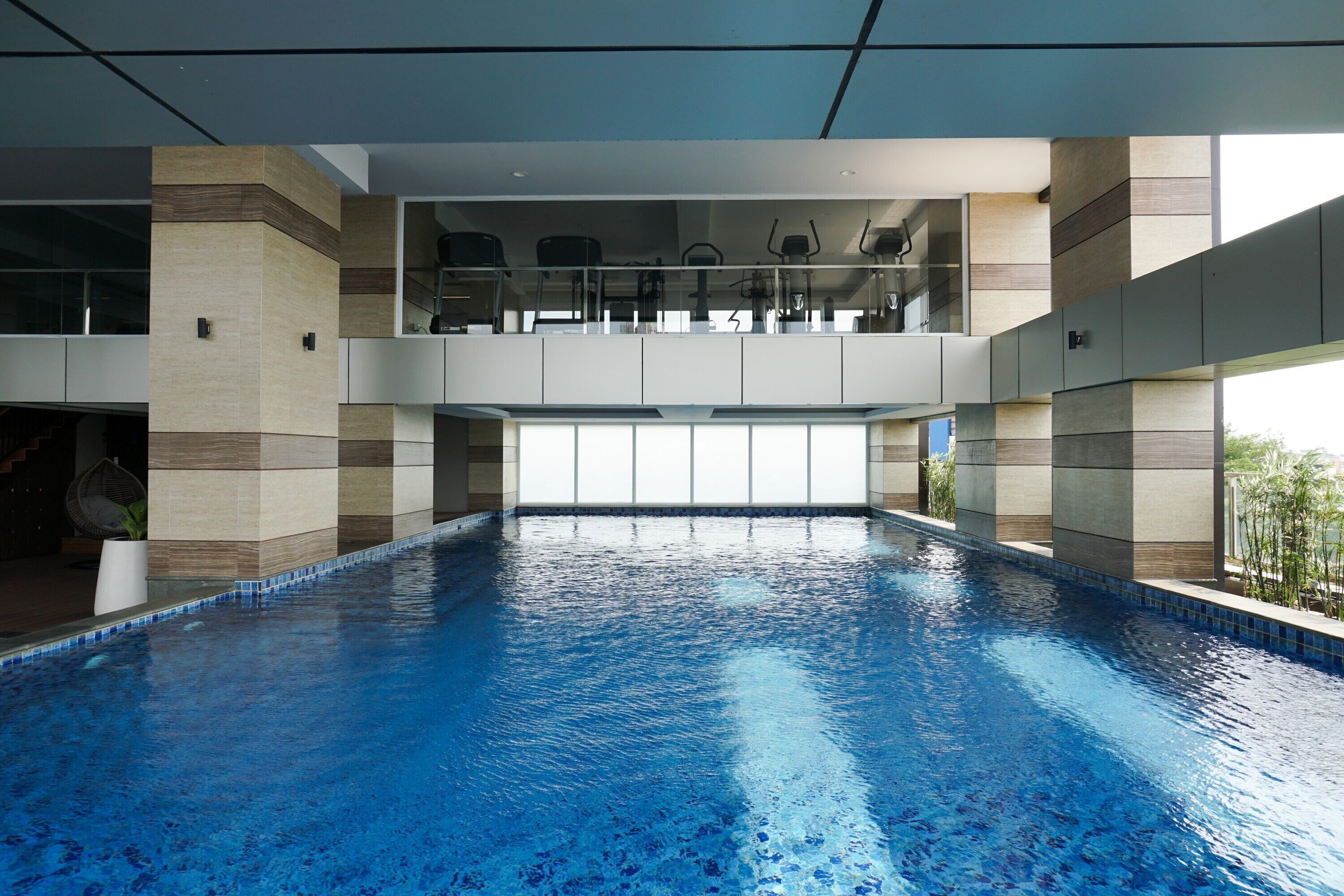 A large indoor swimming pool with a clear view of the sky through the ceiling.