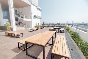 Eine Dachterrasse mit Außenmöbeln, einer Treppe und Blick auf die Stadtlandschaft.