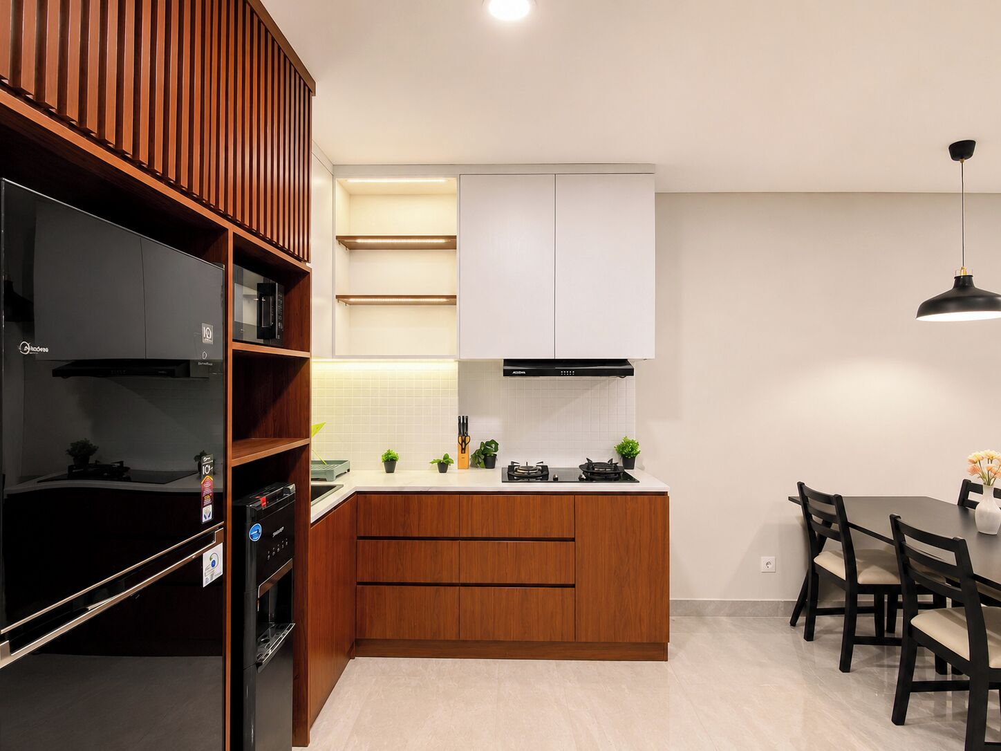 A modern kitchen with wooden cabinets, a built-in oven, and a dining area with a table and chairs.