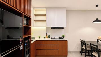 A modern kitchen with wooden cabinets, a built-in oven, and a dining area with a table and chairs.