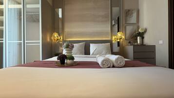 Habitación de hotel con una cama grande, lámparas de noche, un tocador y un espejo.