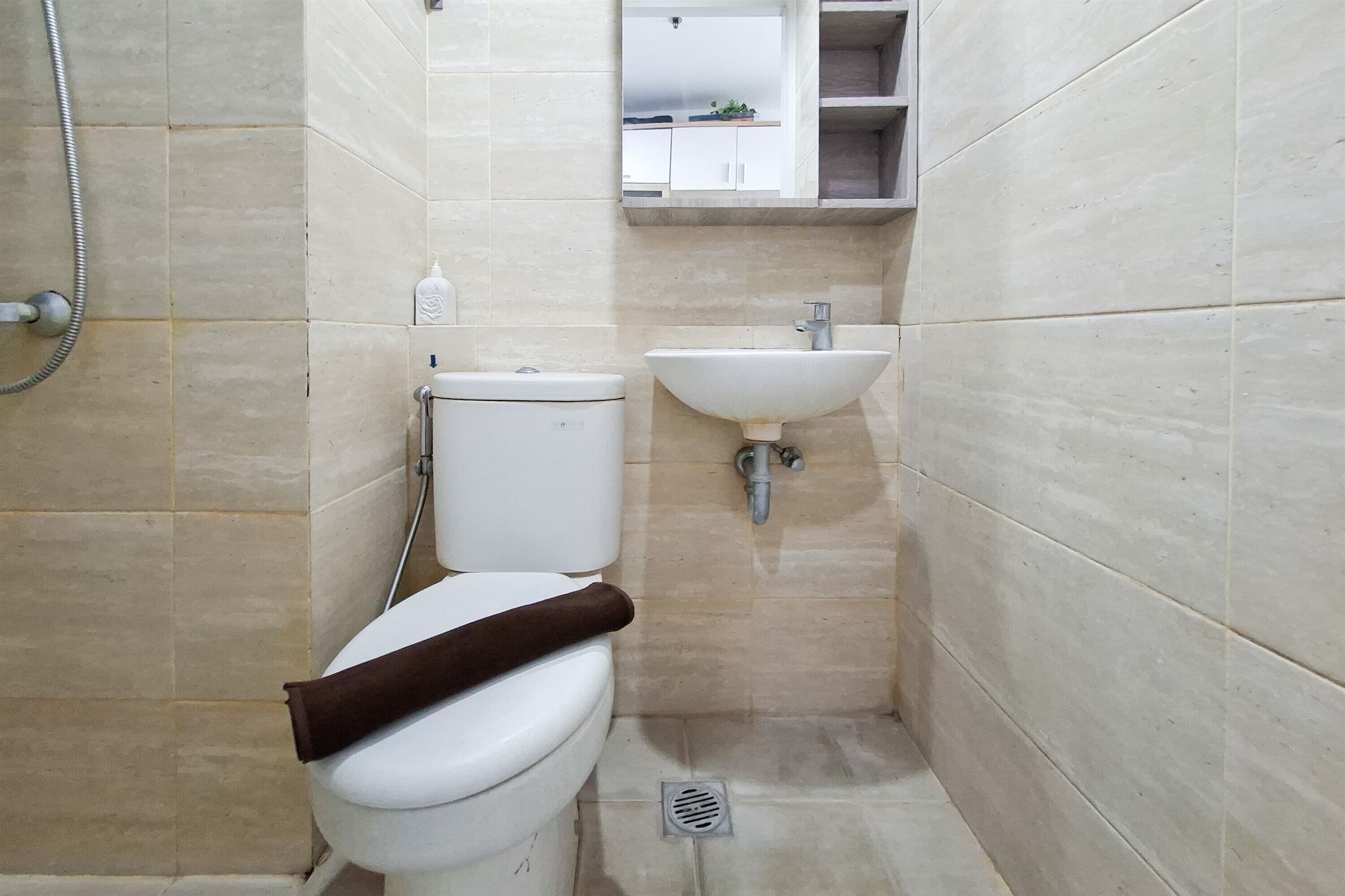 Een compacte badkamer met toilet, wastafel en douche.