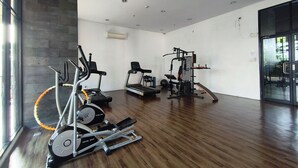 Ett gym med träningsredskap, ett löpband och en roddmaskin.