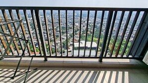 A balcony with a metal railing overlooking a residential area with houses and greenery. - Skyline View 1Br Without Living Room At Apartment Bintaro Embarcadero (Tangerang)