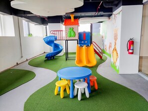 A children's play area with slides, a climbing structure, and a table with stools. - Skyline View 1Br Without Living Room At Apartment Bintaro Embarcadero (Tangerang)