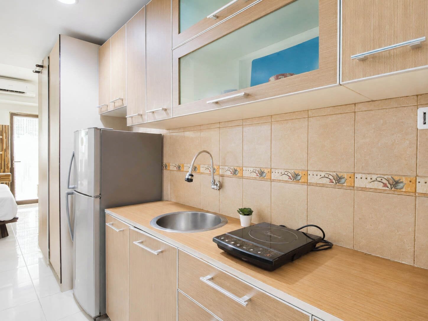 Una cocina equipada con refrigerador, pileta y estufa.