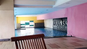 Uima-allasalue, jossa etualalla on penkki, kyltti, jossa ilmoitetaan syvyydeksi 1,4 metriä, ja seinä, jossa on teksti ”TAMAN SA” ja ”SUDIRMAN Executive Residence”.