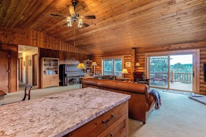 A wooden cabin interior with a kitchen, dining area, and a balcony with a view. - 2.5 Acre Log Cabin, Cascade Views, Dog-Friendly (Bend)