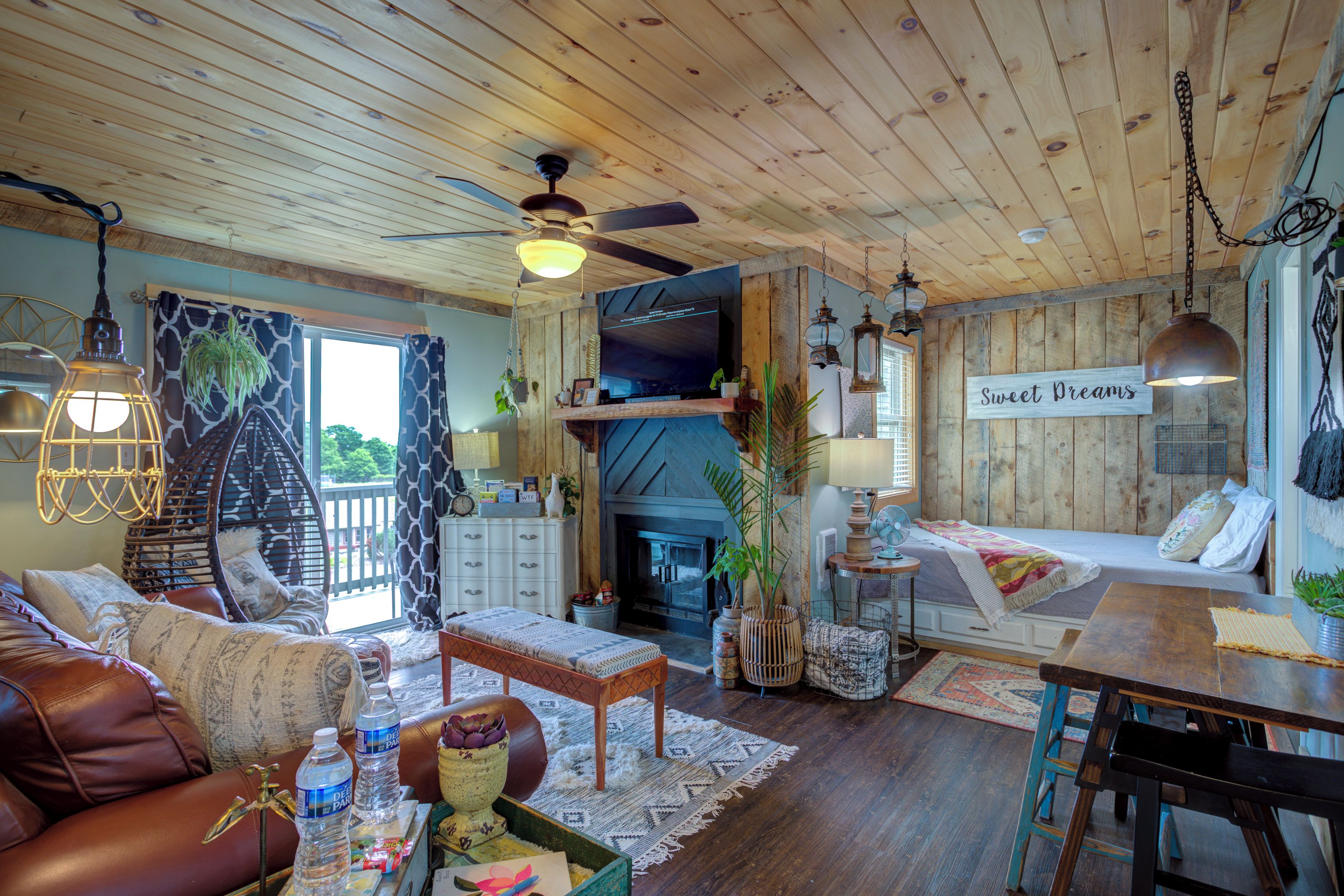 A cozy living room with a sofa, a coffee table, a fireplace, and a sign that reads 'Sweet Dreams'.