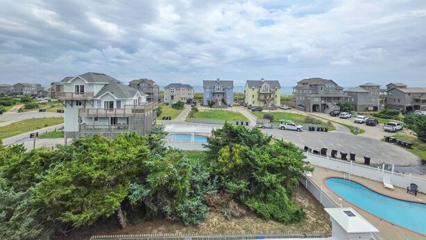 A residential area with houses, a swimming pool, and a road. - 7853 - Anchor Management Spacious 6BR, 5.2BA oceanside home in Frisco for up to 12 guests. (Frisco)
