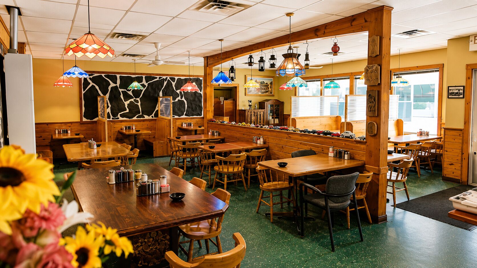 A restaurant interior with wooden tables, chairs, and hanging lamps.