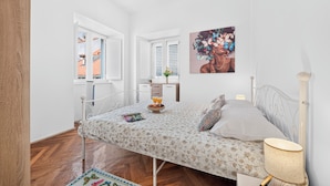 A bedroom with a bed, a desk, a window, and a painting. - Apartment Gracija  2-Bedroom Apartment in Dubrovnik Old Town
 (Dubrovnik)