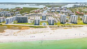 Una zona residenziale costiera con palazzi alti, una spiaggia e un porto turistico.
