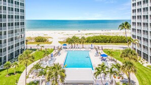 Un resort con piscina, accesso alla spiaggia e edifici a grattacielo.