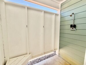Ein Zimmer mit Oberlicht, einer Dusche mit Handbrause und einer kleinen Stufe zu einem Kiesbereich.