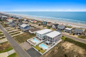 A coastal residential area with houses, a road, and a beach. - Weekend Rescue: 10BR 10.5BA, Ocean Views, Pool, Hot Tub, Elevator, Dog Friendly, Sleeps 22 (Oak Island)