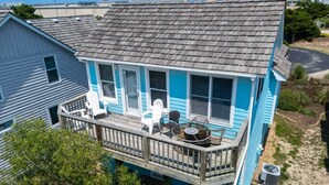 Une maison à deux étages avec un balcon, une petite terrasse et une piscine.