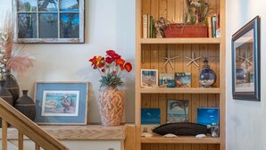 Une bibliothèque en bois, avec des livres, des photos encadrées et des objets décoratifs.