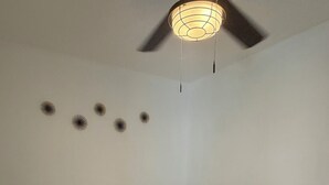 A bedroom with a bed, a ceiling fan, and wall decorations. - Cozy 1-bedroom studio in charming Inglewood with AC (Inglewood)
