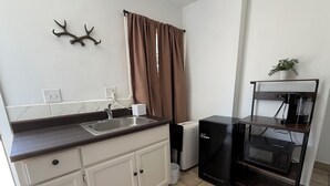 A compact kitchen with a sink, a coffee machine, a mini-fridge, and a microwave. - Cozy 1-bedroom studio in charming Inglewood with AC (Inglewood)